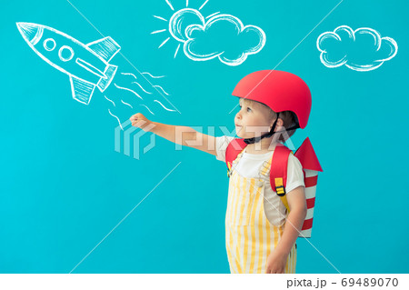 Happy child playing with toy paper wings against 69489070