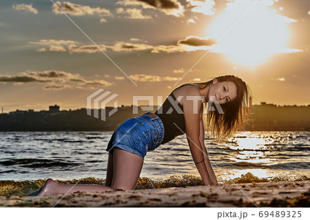A young brunette woman in a black undershirt  69489325