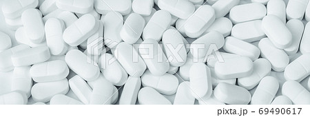 Background of white tablets or pills on the table. Medicine and pharmacy 69490617