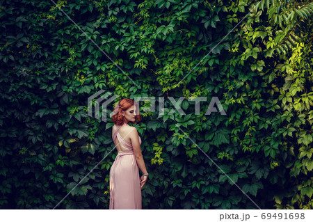 Lovely young woman in a pink dress, waiting for a Lovely young woman in a pink dress, waiting for a 69491698