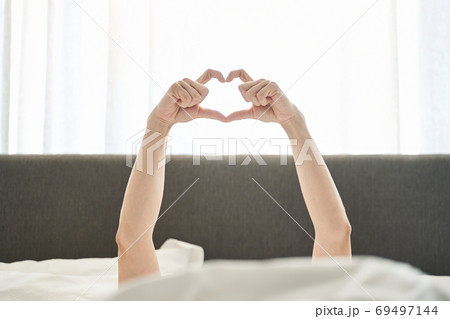 Young woman showing a symbol of love 69497144