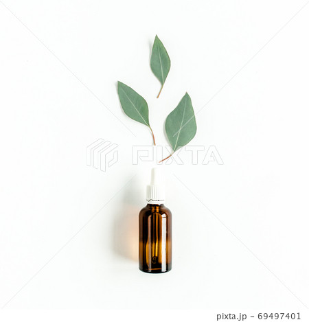 Bottle of eucalyptus essential oil, eucalyptus leaves on white background. Natural Organic cosmetics products. Flat lay, top view. 69497401
