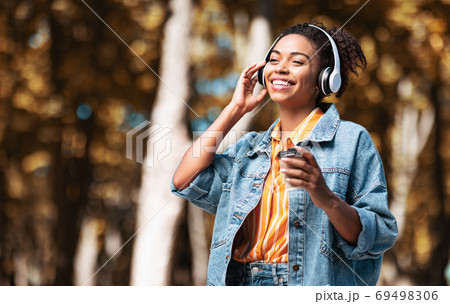 Positive African American Girl Enjoying Music Walking Having Coffee Outdoor Positive African American Girl Enjoying Music Walking Having Coffee Outdoor 69498306