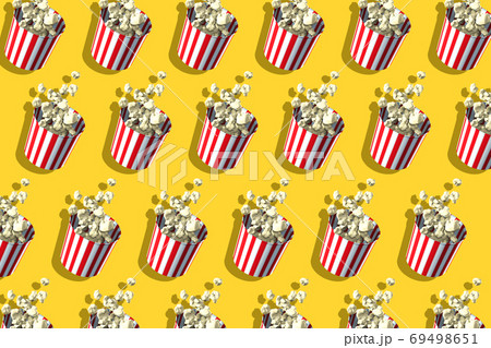 Pattern of popcorn retro boxes on yellow background. Harsh shadow. Cinema theatre food 69498651