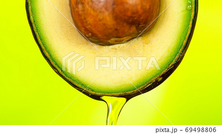 Fresh cut avocado with oil stream. 69498806