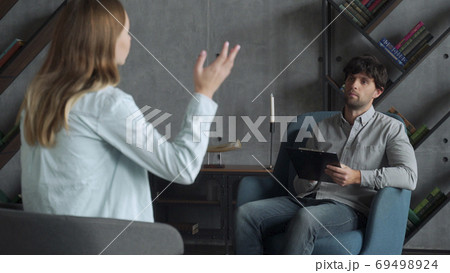 Positive psychoanalyst man conversation with female patient in office room. People, dialogue and psychology concept. 69498924
