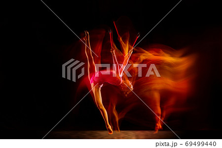 Young flexible female gymnast isolated on black studio background in mixed light, 69499440