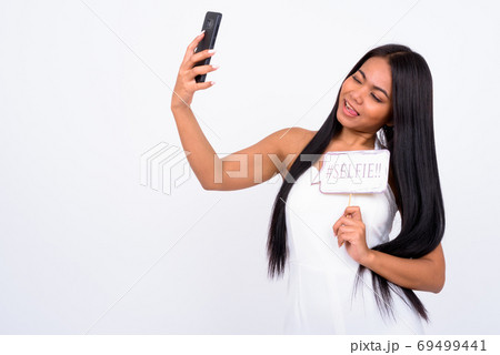 Portrait of happy young Asian businesswoman taking selfie with paper sign 69499441
