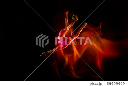 Young flexible female gymnast isolated on black studio background in mixed light, 69499449