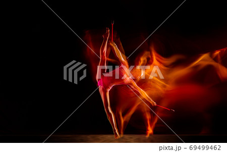 Young flexible female gymnast isolated on black studio background in mixed light, 69499462
