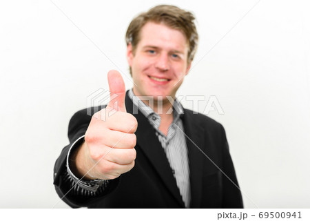 Portrait of happy young handsome businessman giving thumbs up Portrait of happy young handsome businessman giving thumbs up 69500941