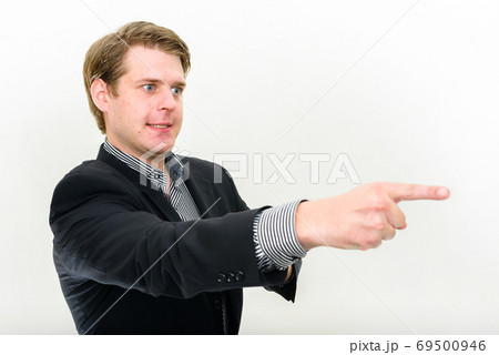 Portrait of stressed young businessman looking angry and pointing finger Portrait of stressed young businessman looking angry and pointing finger 69500946