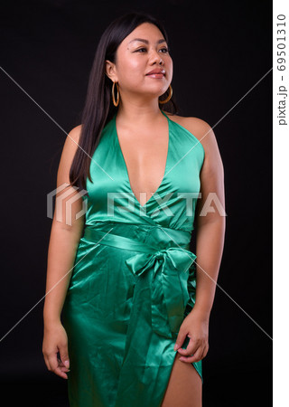 Beautiful overweight Asian woman wearing silky green dress Beautiful overweight Asian woman wearing silky green dress 69501310
