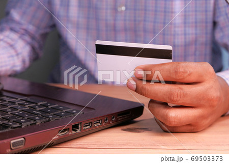 man hands holding credit card and using laptop shopping online  69503373