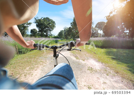 portrait of young beautiful and hipster woman riding bicycle and having fun among nature 69503394