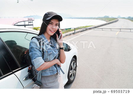 Young asian traveler with car using smart phone while traveling during holiday vacation. Young asian traveler with car using smart phone while traveling during holiday vacation. 69503719