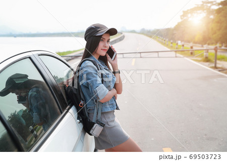Young asian traveler with car using smart phone while traveling during holiday vacation. Young asian traveler with car using smart phone while traveling during holiday vacation. 69503723