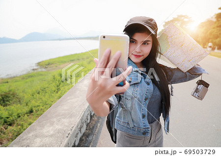 Young asian traveler using smart phone and do self portrait while traveling during holiday vacation. Young asian traveler using smart phone and do self portrait while traveling during holiday vacation. 69503729