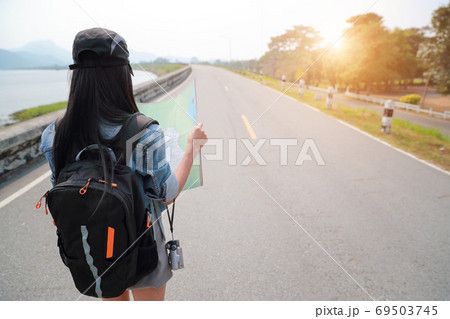 Young asian traveler searching direction on location map while traveling during holiday vacation. Young asian traveler searching direction on location map while traveling during holiday vacation. 69503745