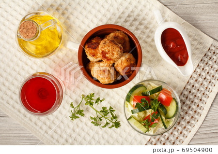 Fried meat cutlets in bowl, salad, glass of wine and bottle with sunflower oil Fried meat cutlets in bowl, salad, glass of wine and bottle with sunflower oil 69504900