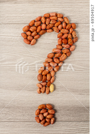 Question mark sign made of peanuts on grey wooden background 69504917