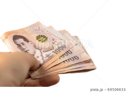 Hand holding Thai currency, 1000 Baht, money banknote of Thailand Hand holding Thai currency, 1000 Baht, money banknote of Thailand 69506633