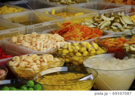 Fruits that have been cut and pickled fruits, sell open in the market. It is placed in a large container for the customer to choose from. 69507087