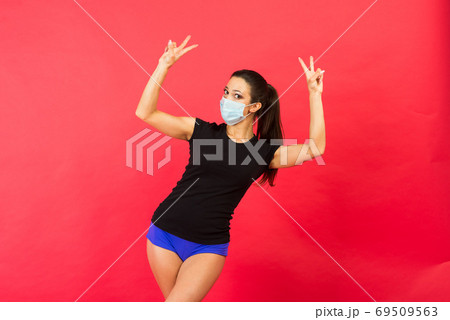 Young fitness woman in sportswear face mask isolated on red background studio. Motivation concept. Young fitness woman in sportswear face mask isolated on red background studio. Motivation concept. 69509563