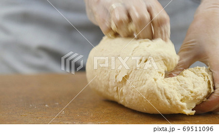woman mother or daughter on the kitchen table makes domestic food pizza, hands work and pushing stir 69511096