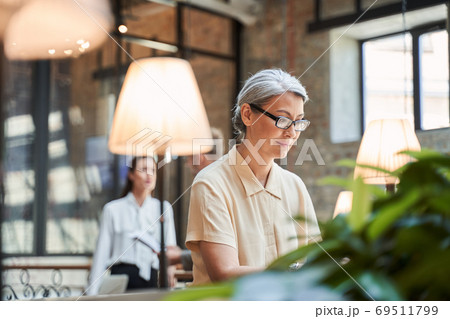 Beautiful female in glasses sitting at the modern place in business center 69511799
