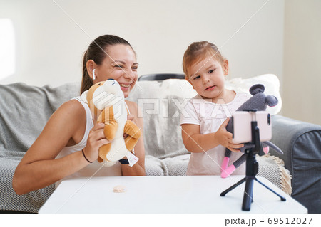 Mother with child streaming online video of unboxing toys. Influencer occupation, mommy blog Mother with child streaming online video of unboxing toys. Influencer occupation, mommy blog 69512027