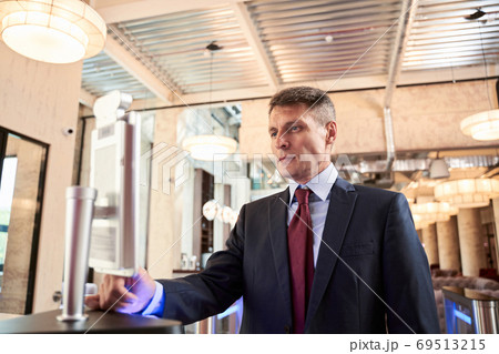 Handsome businessman making check-in at hotel Handsome businessman making check-in at hotel 69513215