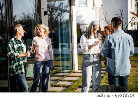 Friends enjoying talking outdoors in the yard Friends enjoying talking outdoors in the yard 69513514