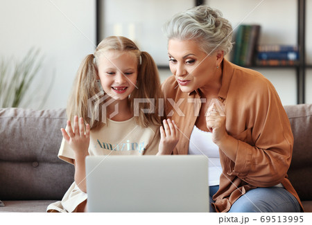 Grandmother helping granddaughter with online studies Grandmother helping granddaughter with online studies 69513995