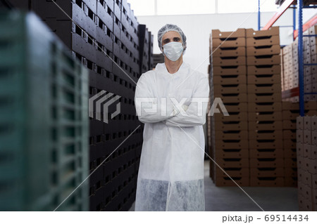 Young man in uniform standing in a warehouse Young man in uniform standing in a warehouse 69514434