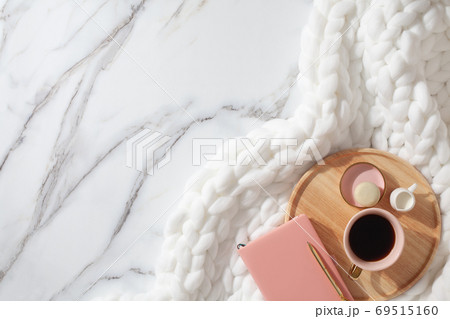 Minimal workspace with diary, pen, cup of coffee, milk, french macaron and white knit cotton plaid 69515160