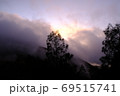 Beautiful pink and purple dawn from behind clouds over the coniferous forest of the Balinese volcano 69515741