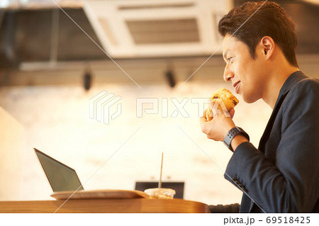 食事をしながらPCを操作する男性 食事をしながらPCを操作する男性 69518425