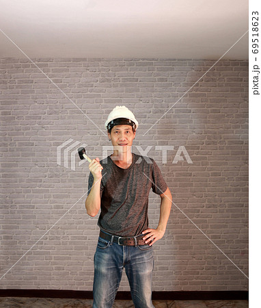 Technician man ware white helmet with dark grey T-shirt and deni Technician man ware white helmet with dark grey T-shirt and deni 69518623