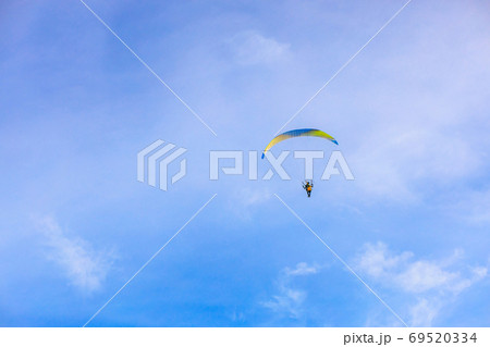 A flying paramotor on a vibrant sky with cloud. A flying paramotor on a vibrant sky with cloud. 69520334
