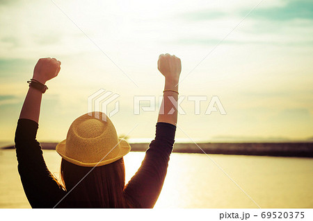 Silhouette of young woman enjoying victory and rise the hand and scream 69520375