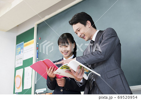 先生に質問をする女子生徒 69520954