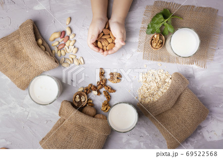 Nuts in burlap bags, zero waste concept. Flat lay. Holding cashew. Nut milk in glasses Nuts in burlap bags, zero waste concept. Flat lay. Holding cashew. Nut milk in glasses 69522568