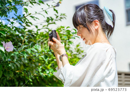 屋外で花を撮影する若い女性 屋外で花を撮影する若い女性 69523773