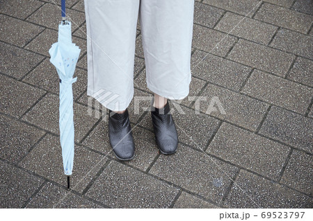 レインブーツと傘を持つ女性の足元 69523797