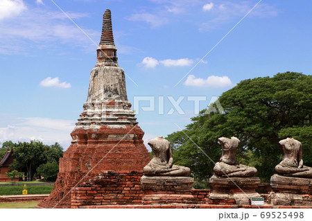Old Buddha statue damaged without head and one of the pagodas in the Chaiwatthanaram Temple Old Buddha statue damaged without head and one of the pagodas in the Chaiwatthanaram Temple 69525498