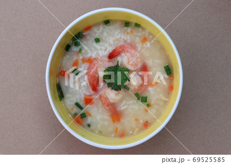 Rice congee mixed with shrimp in the round bowl on the brown floor. Rice congee mixed with shrimp in the round bowl on the brown floor. 69525585