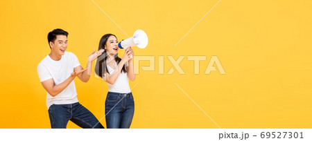 Happy young Asian couple making announcement and presenting Happy young Asian couple making announcement and presenting 69527301