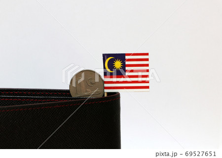 Twenty cents coin of Malaysia and mini Malaysia flag stick on the black wallet on white background. Twenty cents coin of Malaysia and mini Malaysia flag stick on the black wallet on white background. 69527651
