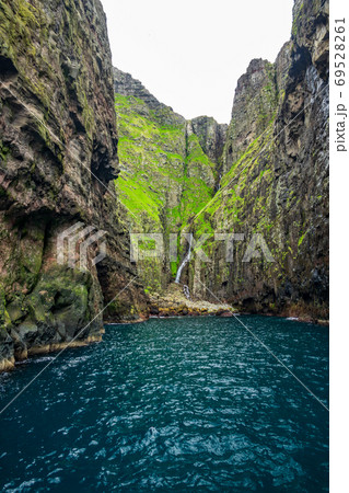 Spectacular Vestmanna cliffs and waterfall in Faroe Islands 69528261